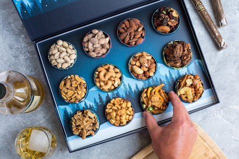 Gourmet nuts advent calendar with 12 tins, including pistachios and cashews, perfect for holiday gifting and seasonal treats.
