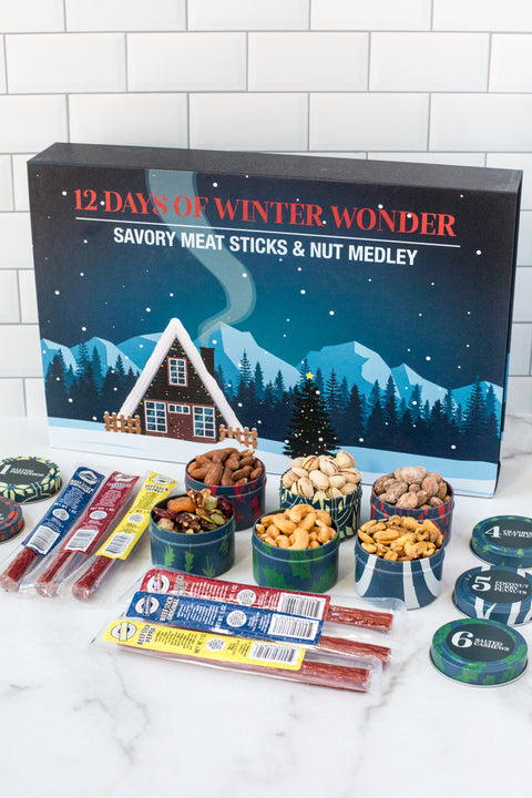 "12 Days of Winter Wonder Gourmet Advent Calendar with Meat Sticks and Nut Medley Gift Box on a Countertop"