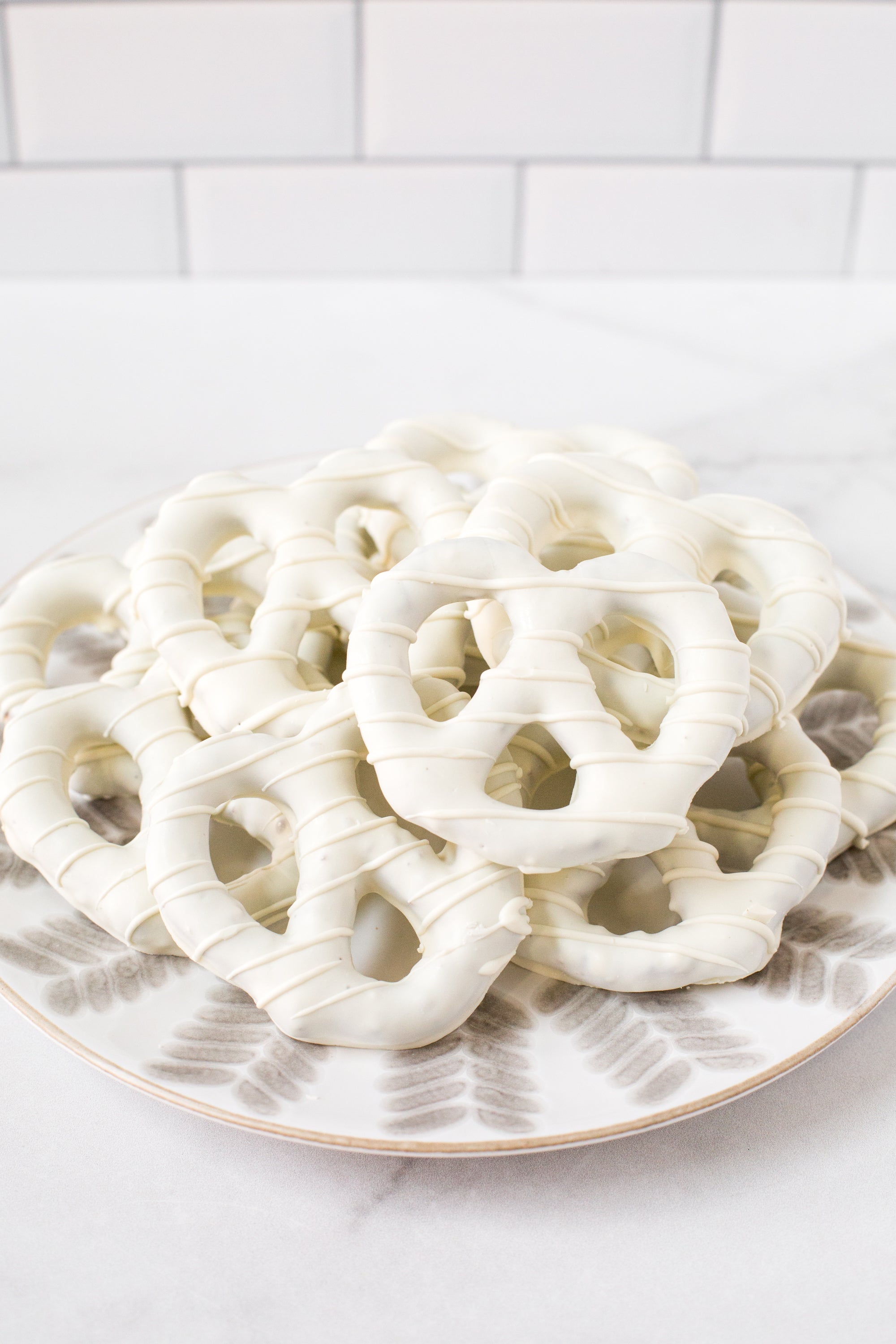 Plate of handcrafted white chocolate-covered pretzels from Pennsylvania, perfect for gifting or snacking.