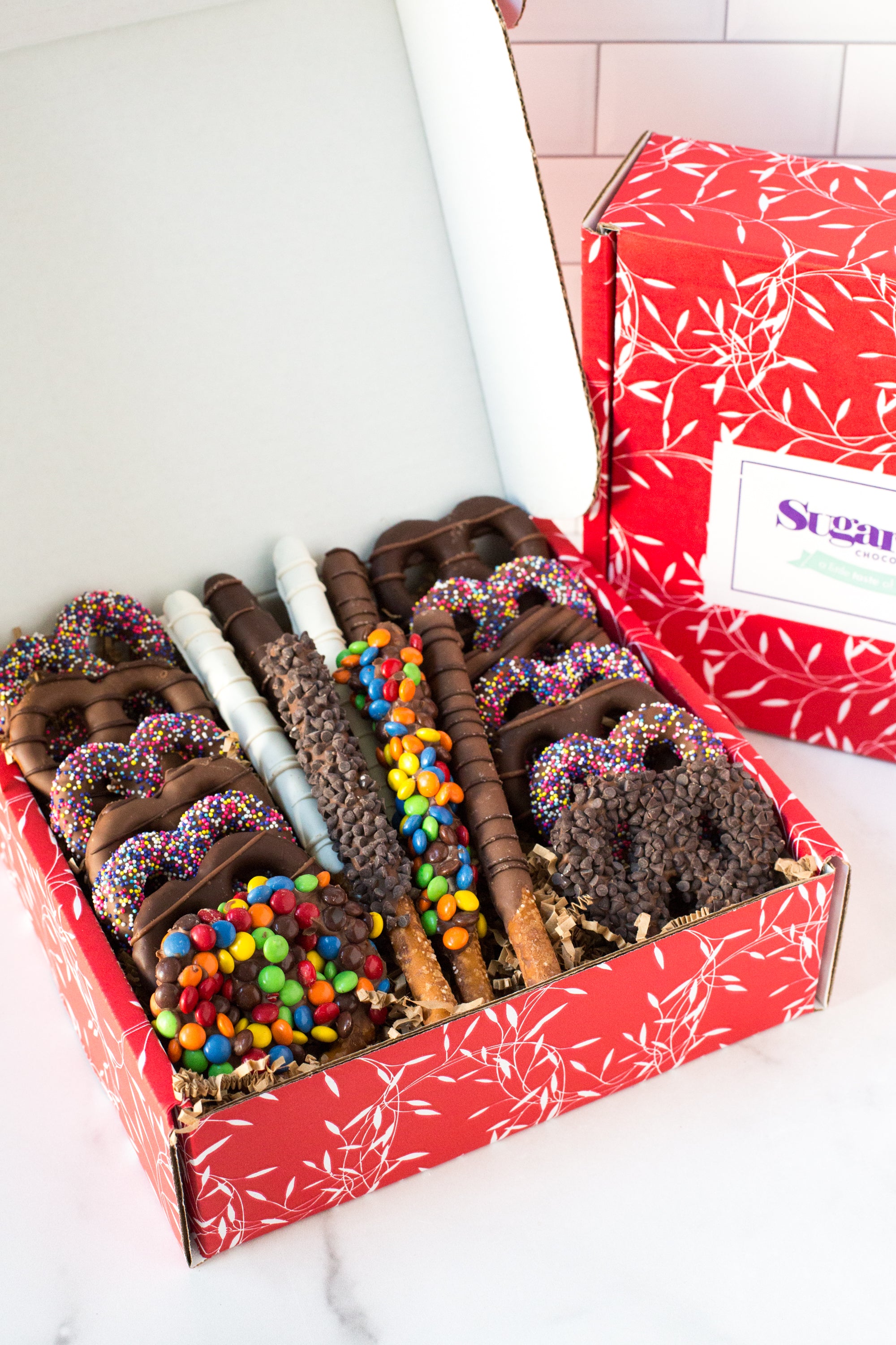 Chocolate Pretzel Passion Gift Box with assorted milk, dark, and white chocolate-covered pretzels topped with colorful candies.