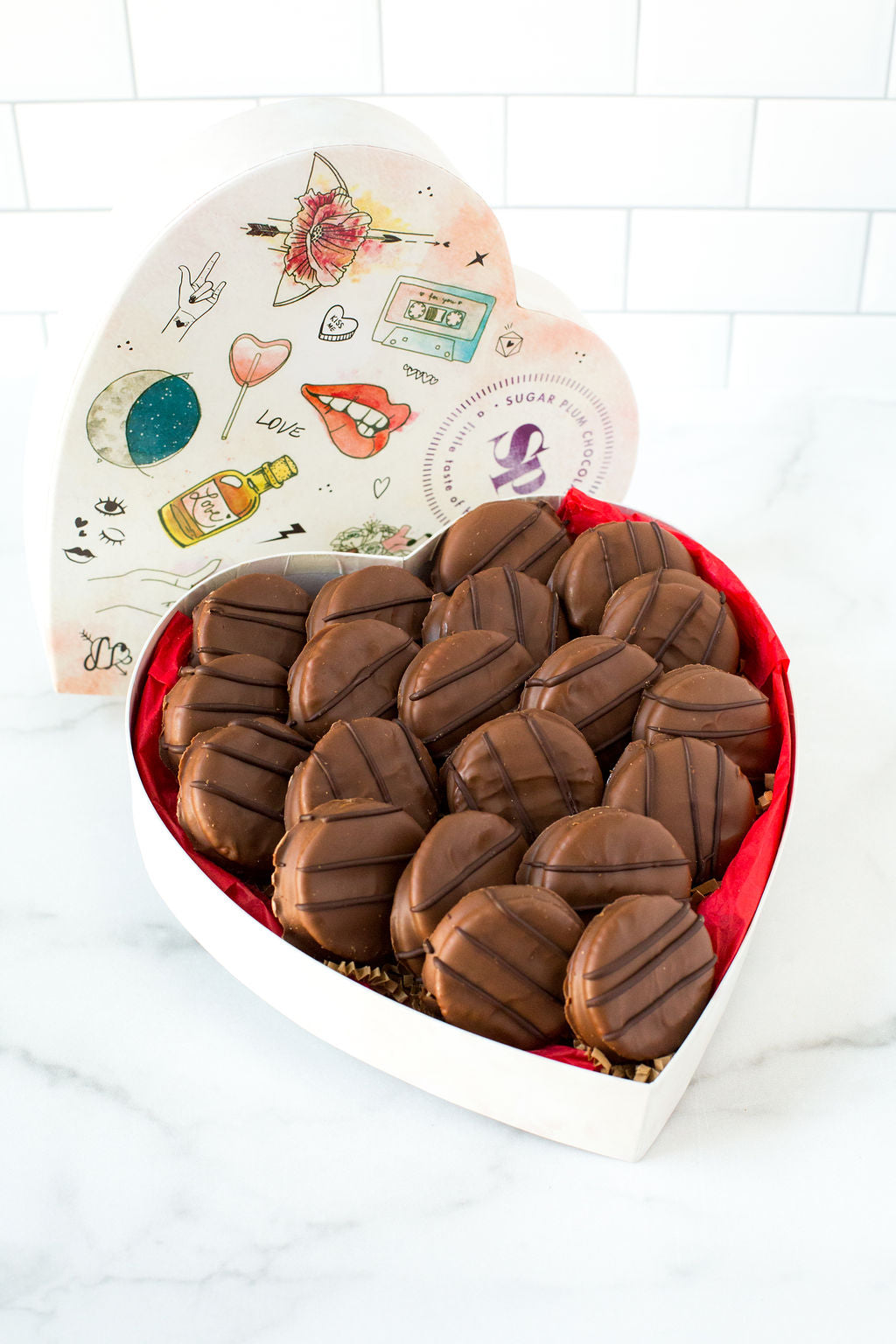 Heart-shaped box of milk chocolate-covered peanut butter cracker cookies, featuring 20 handcrafted sweet and salty treats.