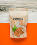 "Kettle-Cooked Pumpkin Spice Almonds in festive packaging on an orange background"