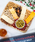Gourmet advent calendar with savory meat sticks, nut medley, cheese, and olives on a festive platter for holiday celebration.