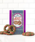 Holiday gift box of milk chocolate-covered pretzels with festive packaging and colorful design.