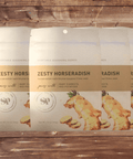 Five packs of Zesty Horseradish Vegetable Seasoning on a wooden background.
