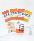 BBQ Blends 4 Flavor Spice Packets featuring savory, sweet, spicy, and tangy seasonings with recipe guide on marble surface.