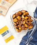 Roasted potatoes seasoned with Tangy Memphis spice mix from BBQ Blends, served in a glass dish on a white countertop.