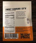 Sweet Kansas City BBQ seasoning blend package with nutrition facts and ingredients by Sugar Plum on a wooden surface.