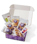 Gourmet snacks in Sugar Plum Comfort Box, perfect for sympathy or get-well gift, featuring sweet and salty treats in open package.