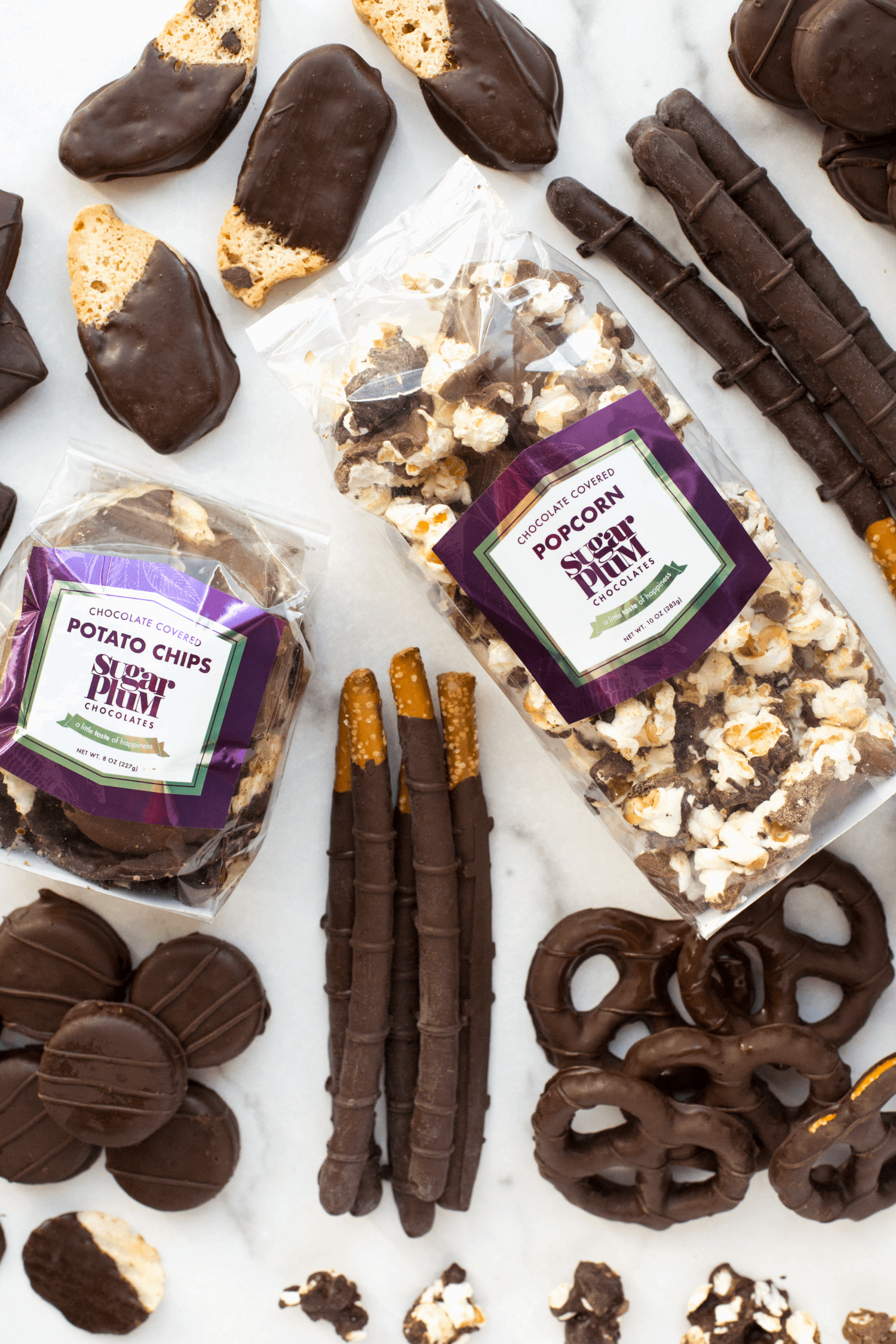 Gourmet dark chocolate gift box assortment with chocolate-covered popcorn, potato chips, pretzels, and biscotti for special occasions.