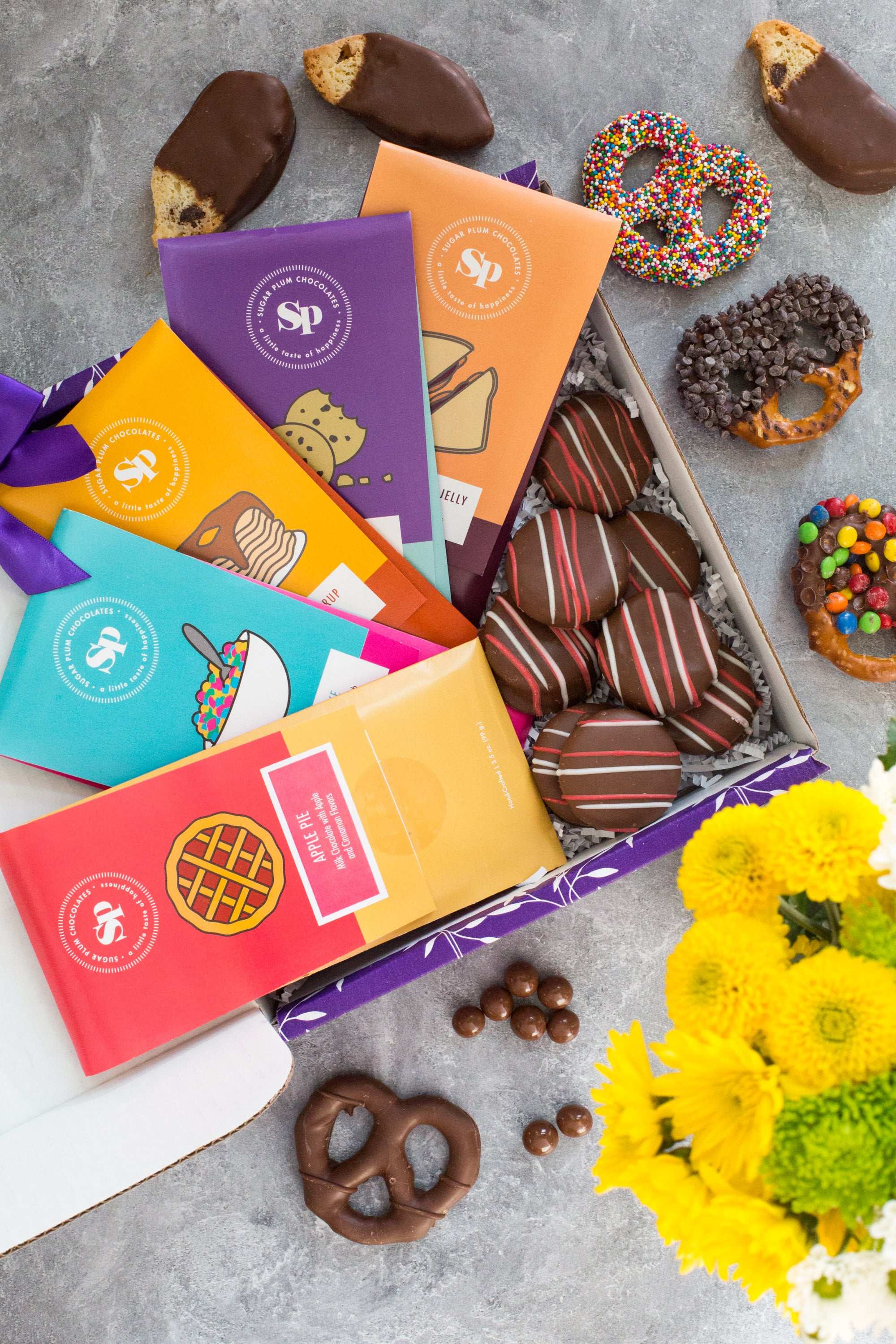 Nostalgic Chocolate Bar Gift Box with assorted handcrafted treats, colorful packaging, and vibrant flowers; perfect for all occasions.