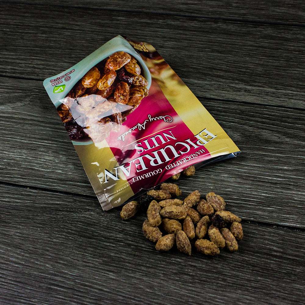 Epicurean Nuts Cherry Almonds spilled from 4 oz resealable bag, showcasing gourmet California almonds with natural cherry flavor.
