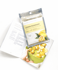 Lemon Rosemary Vegetable Seasoning blend packet with cookbook and roasted potatoes.