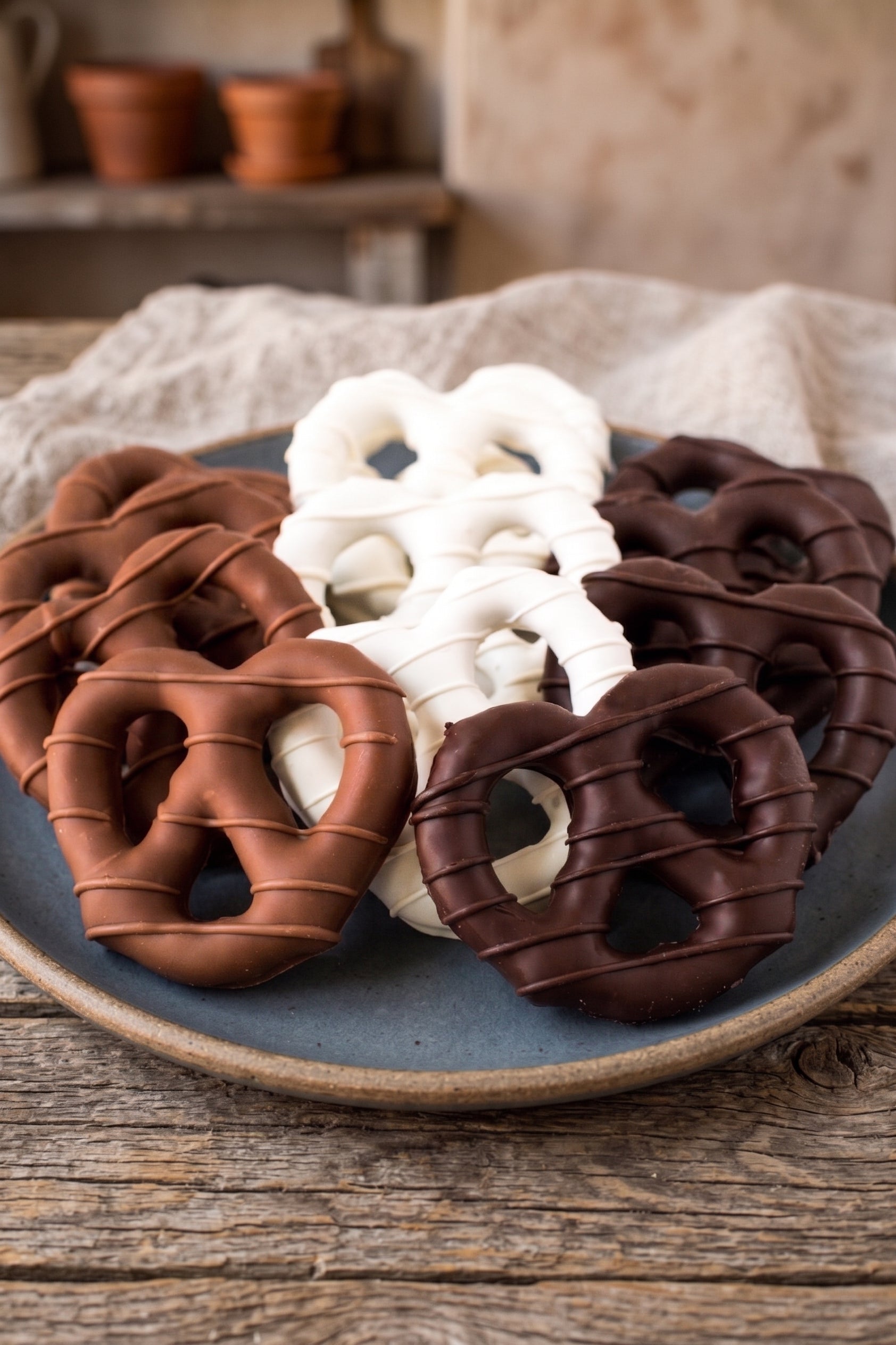 Sugar Plum Assorted chocolate covered pretzels on a plate with a rustic background