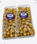 Two bags of Sugar Plum caramel corn with white and milk chocolate drizzle, packaged elegantly for gifting.