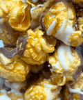 Gourmet caramel corn drizzled with white and milk chocolate, showcasing a sweet and crunchy handcrafted snack.