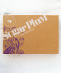 Brown Sugar Plum Chocolates gift box on white marble surface.
