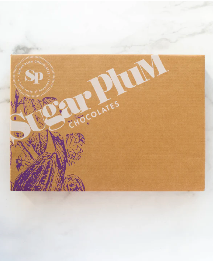 Brown Sugar Plum Chocolates gift box on white marble surface.