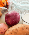 Fresh vegetables and creamy sauce on kitchen counter for cooking.