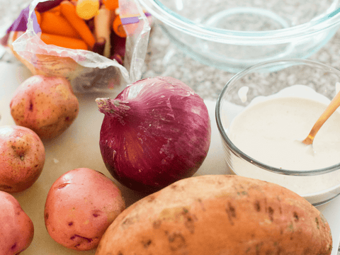 Fresh vegetables and creamy sauce on kitchen counter for cooking.