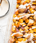 Roasted vegetables with creamy sauce featuring potatoes, carrots, and onions in a baking dish, perfect for a zesty horseradish seasoning.