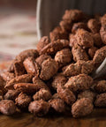 Gourmet cherry-flavored almonds spilling from a jar, showcasing Sugar Plum's Epicurean Nuts, perfect for snacking and dishes.