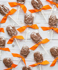 Handcrafted milk chocolate turkey lollipops with orange bows, perfect Thanksgiving gift or party favor, 10-pack on white background.