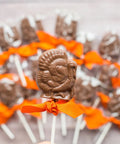 Gourmet milk chocolate turkey lollipops with orange bows, perfect for Thanksgiving gifts or party favors, handcrafted and individually wrapped.