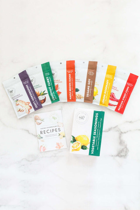 Veggie Lover's Cooking Spice Kit with six global spice packets and plant-based recipe book on a marble surface