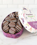 The image shows a well-packed egg-shaped stainless box with chocolate-covered cookies.