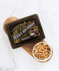 Gourmet Beer & Bourbon Liquor Peanuts Tin with roasted peanuts on wooden board.