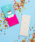 Nostalgic chocolate bar with colorful cereal-inspired packaging and toppings, handcrafted as part of Sugar Plum's unique candy collection.