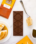Nostalgic Chocolate Bar with Pancakes & Syrup flavor, surrounded by pancake stacks and syrup, from Sugar Plum's handcrafted collection.