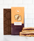 Nostalgic Peanut Butter & Jelly Chocolate Bar with peanut butter and jelly sandwich on a white background.