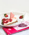 Strawberry cheesecake white chocolate bar with fresh strawberries on a plate, perfect gourmet dessert for gifting and indulging.