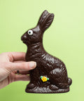 Handmade dark chocolate Easter bunny with a spring flower, wrapped in a cello bag with a bow, perfect for holiday baskets.