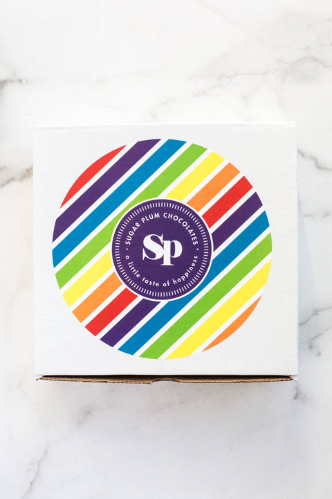 White box type with a rainbow color circle in the center.