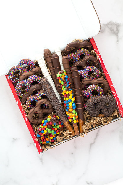 Assorted chocolate-covered pretzel gift box with colorful toppings, perfect for gifting and holiday treats.