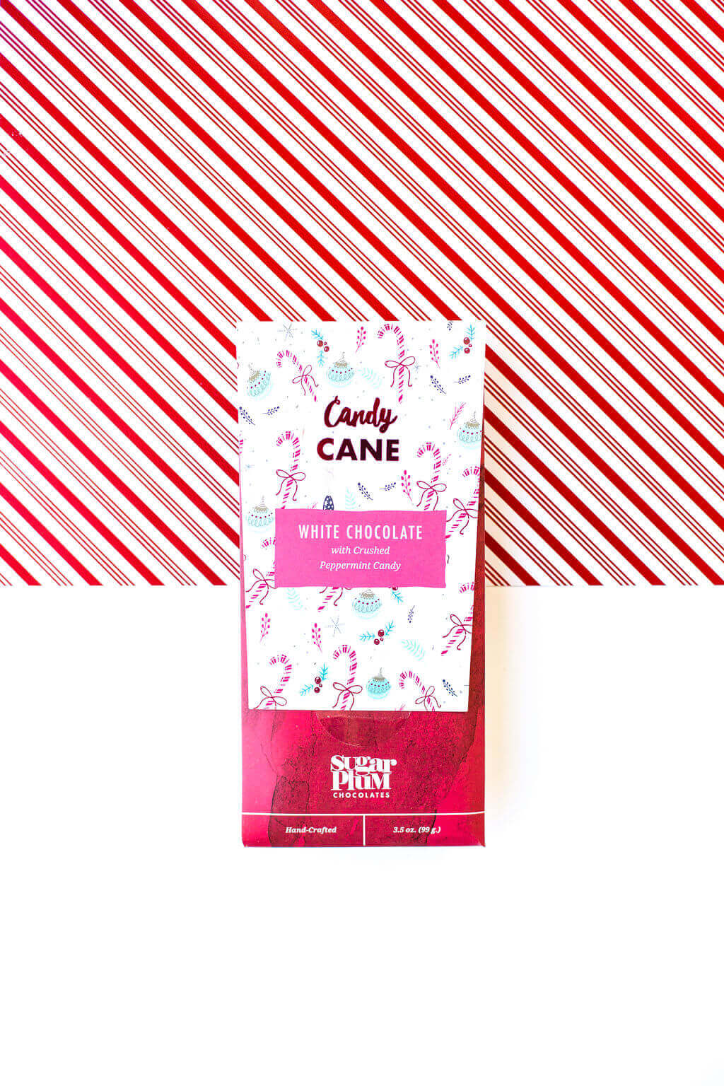 Candy Cane White Chocolate Bar packaging with festive peppermint design, set against red and white striped background.