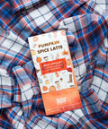 Pumpkin Spice Latte white chocolate bar on cozy plaid fabric, showcasing fall-inspired packaging with autumn-themed illustrations.