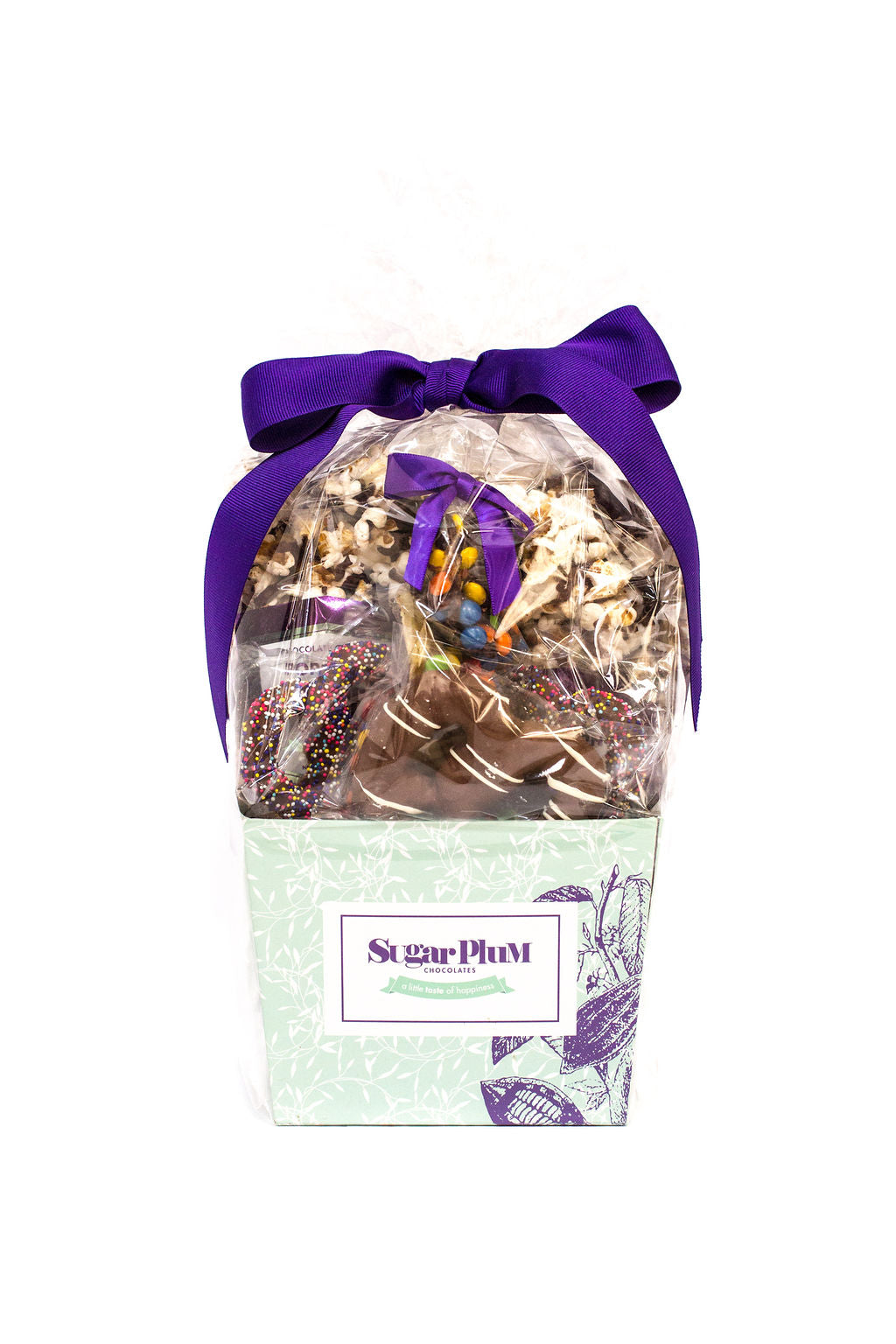 Gourmet chocolate gift basket by Sugar Plum with purple bow, featuring chocolate-covered snacks for holidays and special occasions.