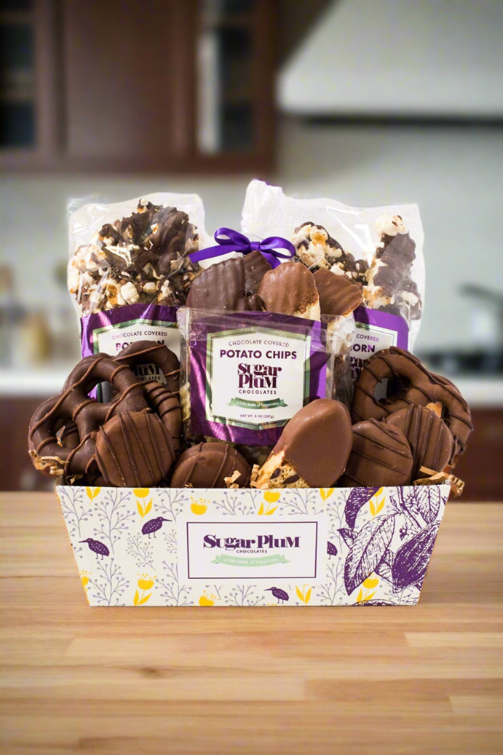 Sugar Plum Chocolate Mountain Gift Assortment basket  with  the following chocolates inside:  (2) Bags of Chocolate-Covered Popcorn (10 oz) (1) Bag of Chocolate-Covered Potato Chips (8 oz) (4) Milk Chocolate-Covered Sandwich Cookies (1) Milk Chocolate-Dipped Biscotti (3) Milk Chocolate-Covered Pretzel Rounds (2) Dark Chocolate-Covered Pretzel Rounds (2) Milk Chocolate-Covered Marshmallows (2) Dark Chocolate-Covered Marshmallows