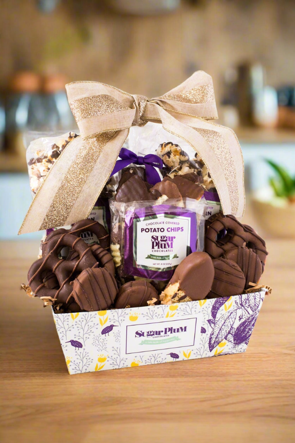 Sugar Plum Chocolate Mountain Gift Assortment basket  with  the following chocolates inside:  (2) Bags of Chocolate-Covered Popcorn (10 oz) (1) Bag of Chocolate-Covered Potato Chips (8 oz) (4) Milk Chocolate-Covered Sandwich Cookies (1) Milk Chocolate-Dipped Biscotti (3) Milk Chocolate-Covered Pretzel Rounds (2) Dark Chocolate-Covered Pretzel Rounds (2) Milk Chocolate-Covered Marshmallows (2) Dark Chocolate-Covered Marshmallows