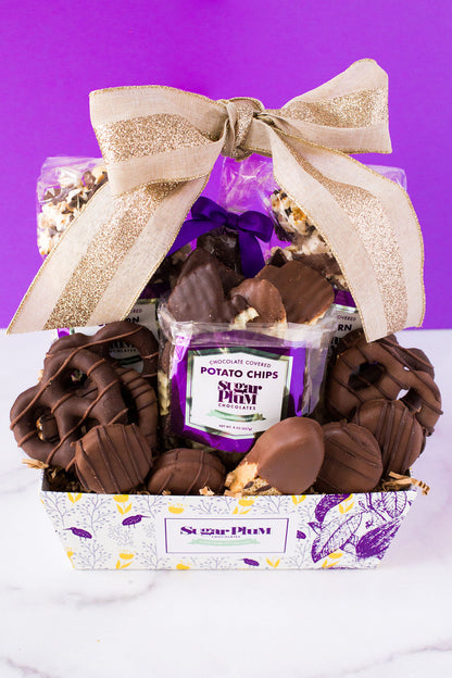 Chocolate Mountain Gift Basket with 17 handcrafted chocolates by Sugar Plum, featuring a festive bow on a vibrant backdrop.