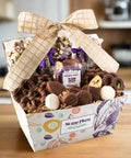 Gourmet chocolate gift basket with 25 handcrafted treats by Sugar Plum, featuring milk, dark, and white chocolate snacks, adorned with a bow.