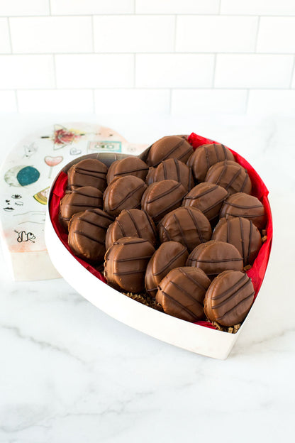 Heart-shaped box of milk chocolate-covered peanut butter cracker cookies, perfect sweet and salty treat with 20 handcrafted pieces.