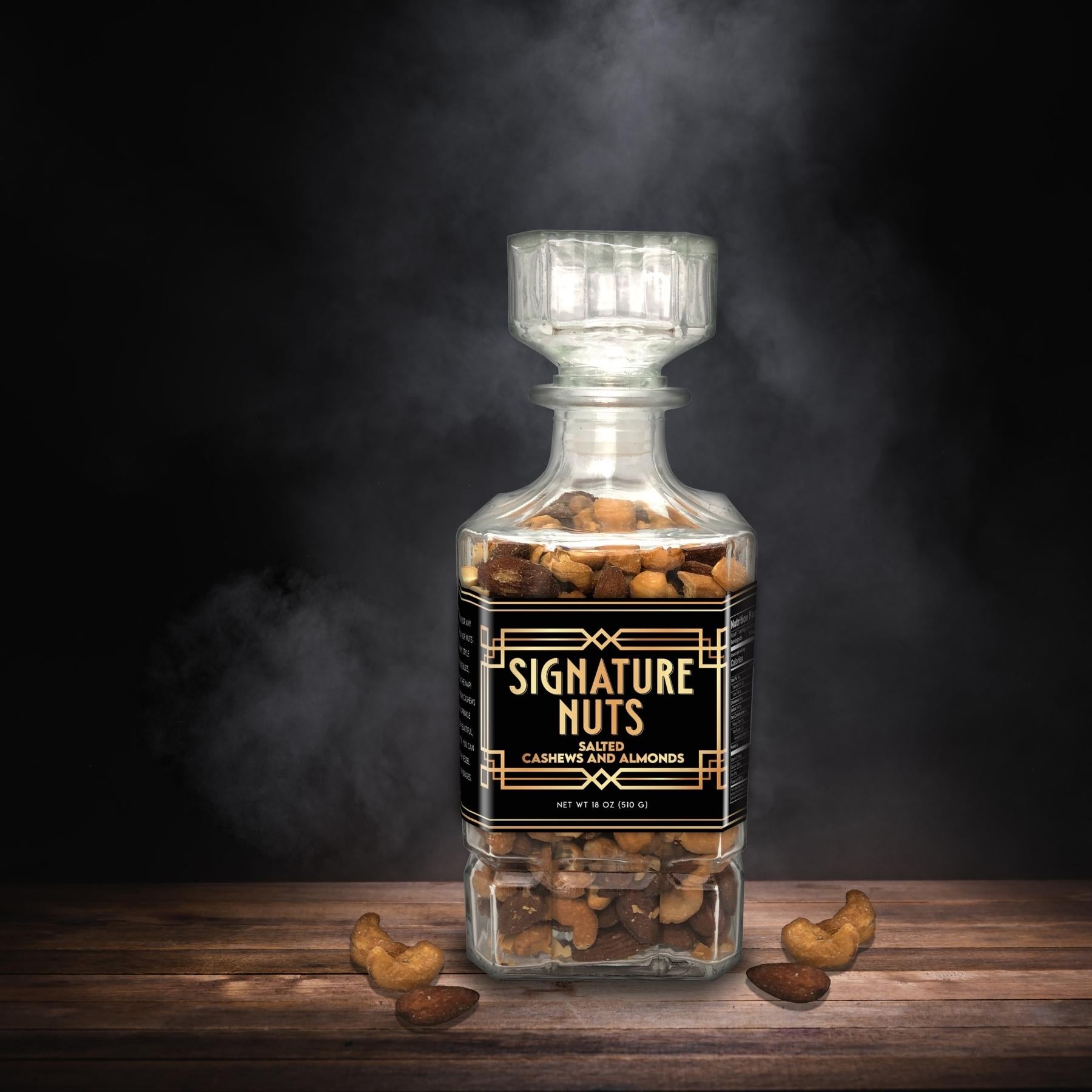 Signature Salted Cashew and Almonds in Glass Decanter with Smoke in Black Background