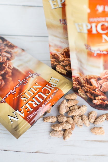 Epicurean Nuts Pumpkin Spice Almonds in packaging with scattered almonds on white background.