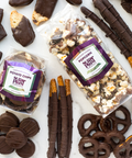 Gourmet dark chocolate gift box assortment with chocolate-covered popcorn, potato chips, pretzels, and biscotti for special occasions.
